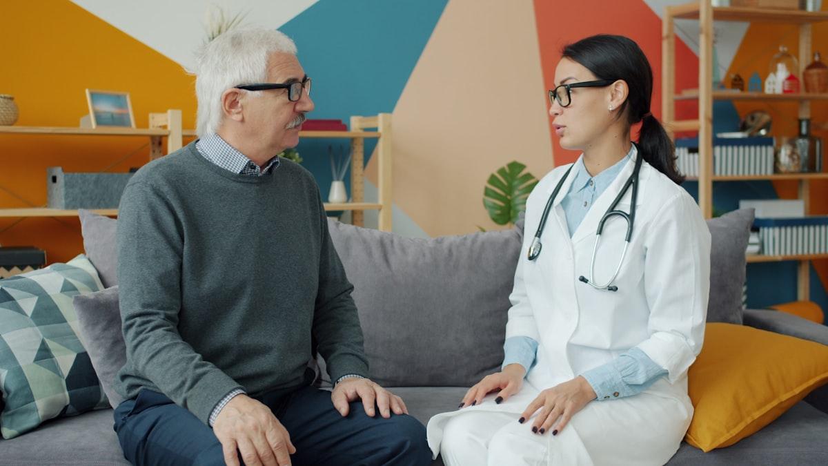 A phlebotomist visiting an elderly patient at home for a blood sample collection